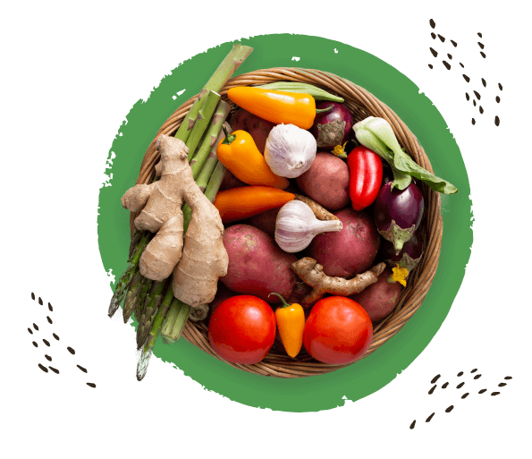 плетёная большая тарелка, вид сверху,на зелёном фоне, на ней разные овощи, спаржа, помидоры, чеснок, перец сладкий, баклажан, картофель и корень имбиря