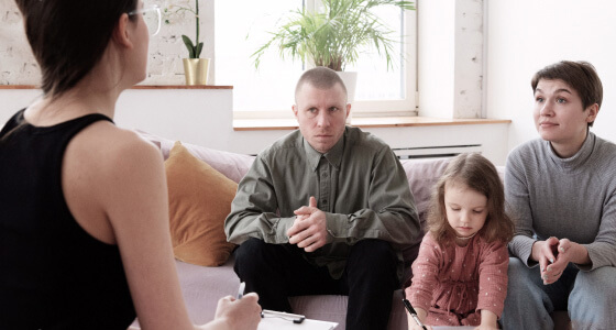 родители и малыш, занимающиеся терапией